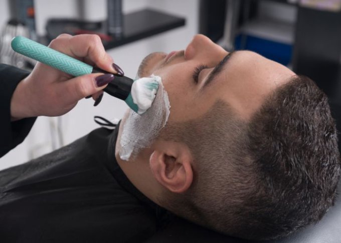 Fryzjer używa kosmetyków do golenia do profesjonalnej pielęgnacji